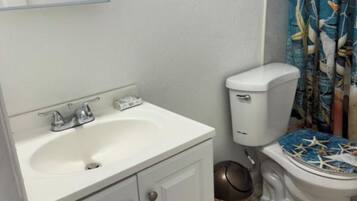 Ein Badezimmer mit Waschbecken, Toilette und Duschvorhang.