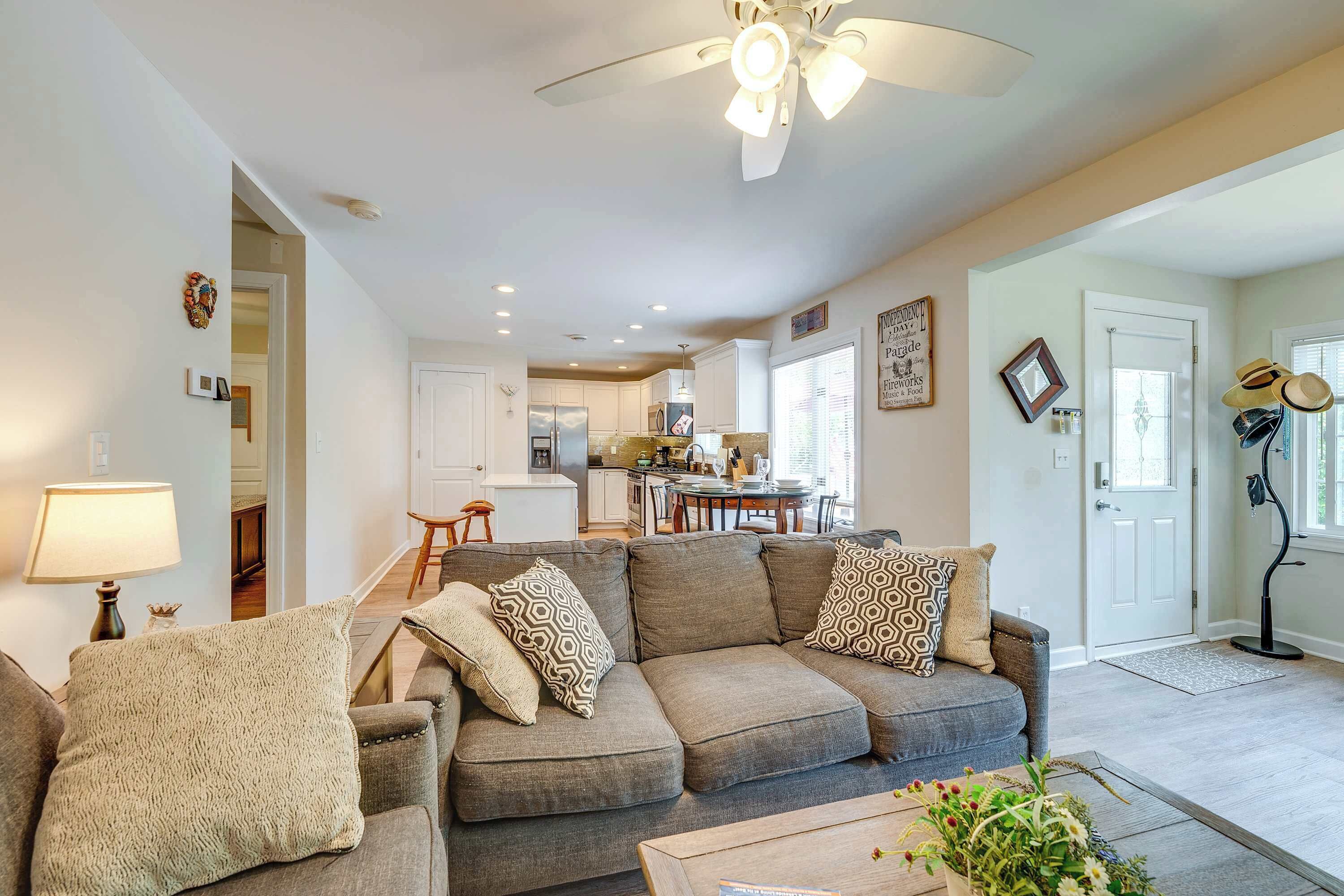 A modern living room with a sectional sofa, a coffee table, and a ceiling fan.
