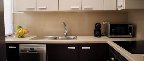 A modern kitchen with a stainless steel sink, a microwave, and a dishwasher.