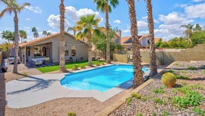 A backyard with a swimming pool, palm trees, and a house. - Pool, Fun & Relaxation | Stylish Scottsdale Stay (Scottsdale)