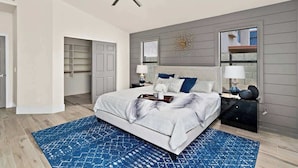 A modern bedroom with a large bed, a ceiling fan, a nightstand with a lamp, and a built-in wardrobe. - Pool, Fun & Relaxation | Stylish Scottsdale Stay (Scottsdale)
