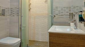 A modern bathroom with a glass shower enclosure, a wooden vanity, and a toilet. - Luxury Herculaneum in Naples station train (Napoli)