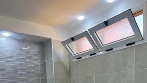 Ein modernes Badezimmer mit Toilette, Waschbecken und Duschbereich.
