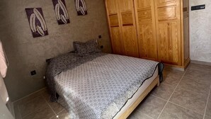 Ein Schlafzimmer mit einem Bett, einem Kleiderschrank und Wandbildern.