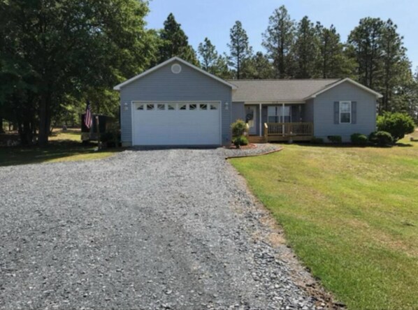 A single-story house with a garage, a front lawn, and a driveway. - 3-bedroom house in charming Jackson Springs. Not to far from the course. (Jackson Springs)