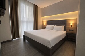 A modern hotel room with a large bed, wooden headboard, two bedside tables with lamps, and a large window with curtains. - Rest by Dedeman Sapanca (Sapanca)