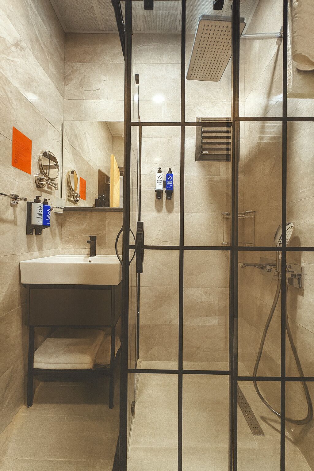 A modern bathroom with a glass partition, a sink, a mirror, and a shower area.