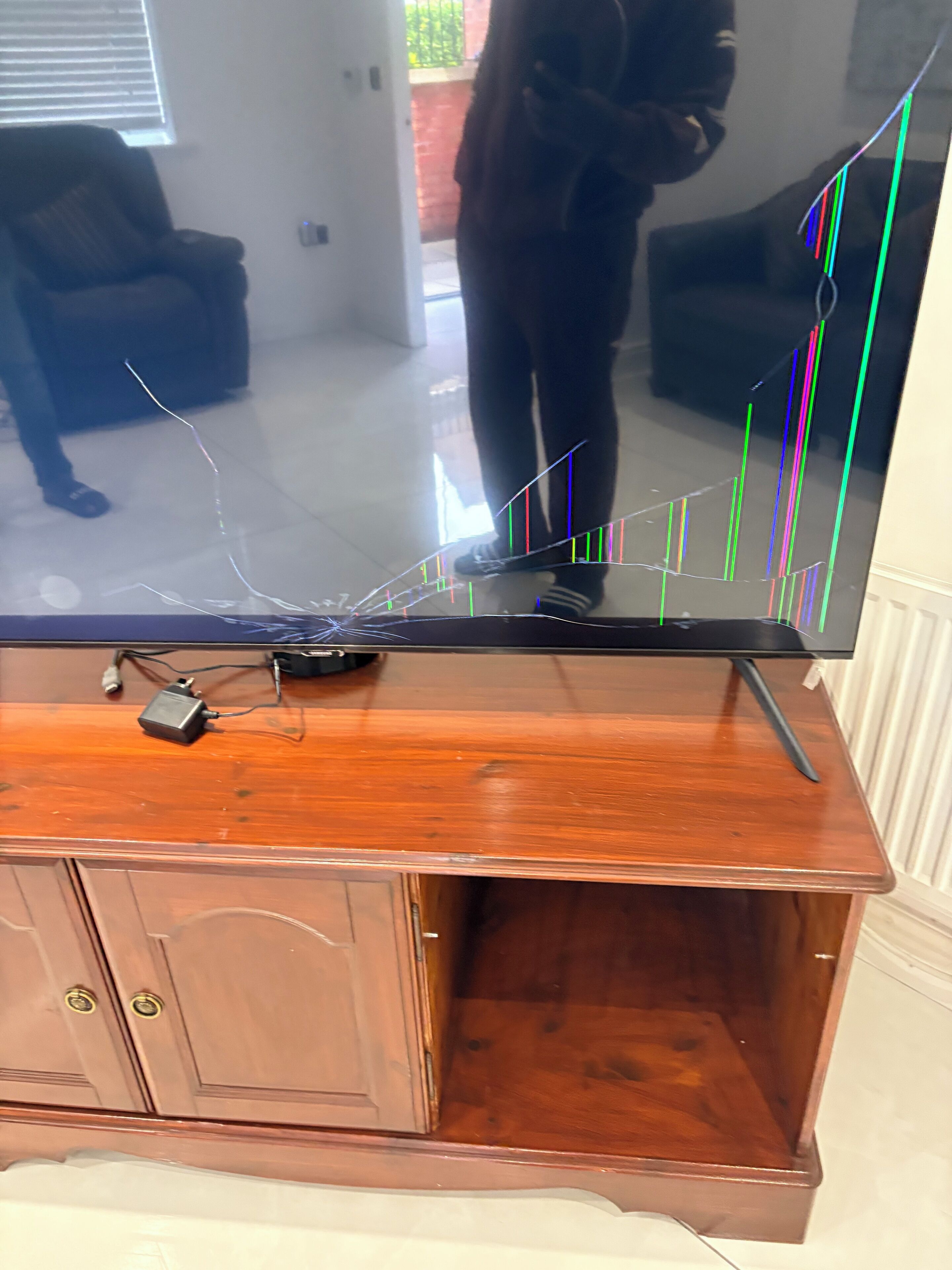 Een houten tv-meubel met een grote flatscreen-tv waarop een kleurrijk diagram staat.