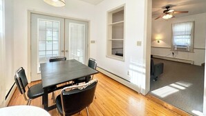 A spacious room with a large dining table, chairs, and a ceiling fan. There are built-in shelves and a window providing natural light. - 2 Bedroom Unit 5 Min to Walk GMC (Danville)