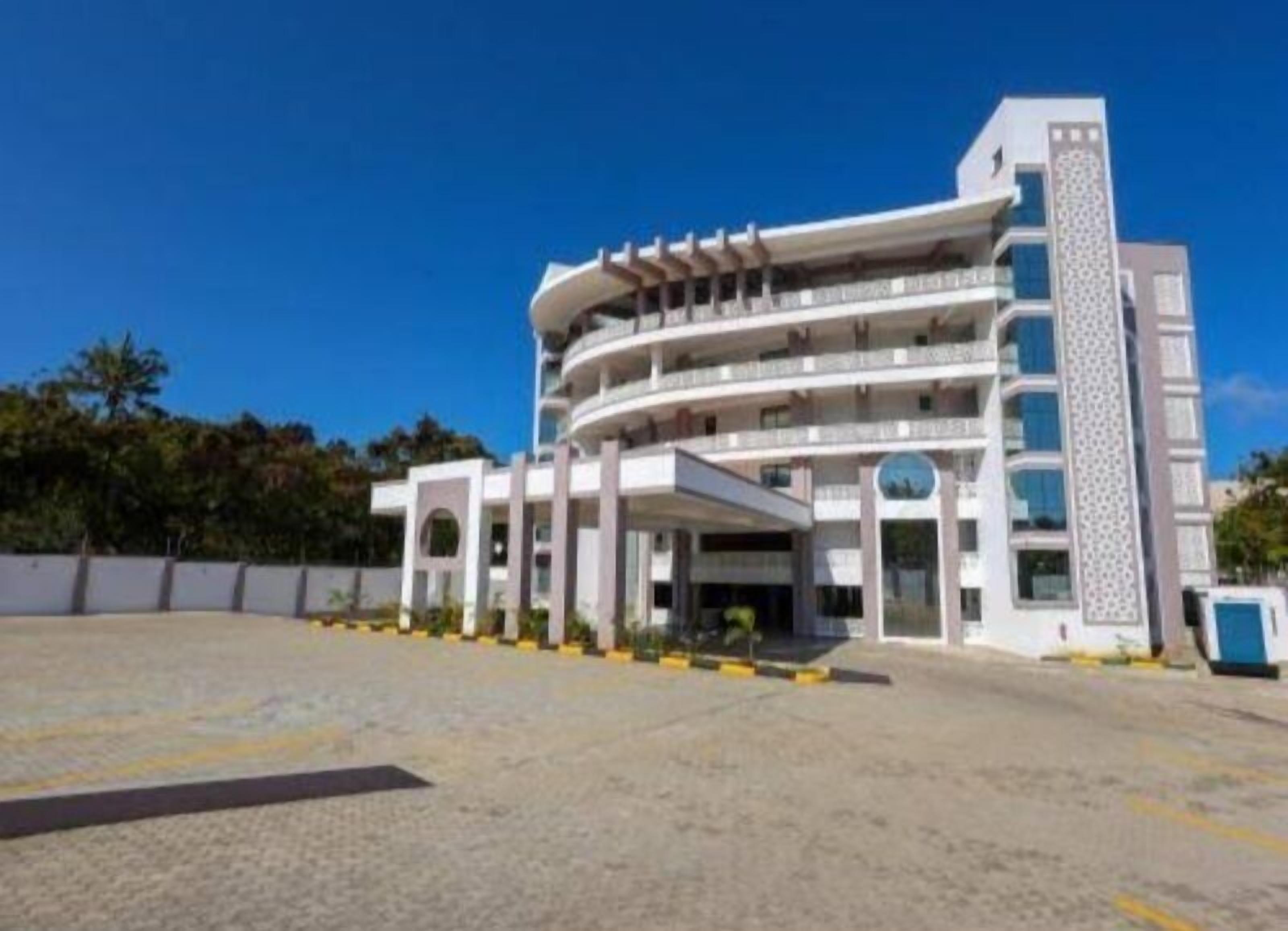 A multi-story hotel with a central courtyard, balconies, and a patterned facade.