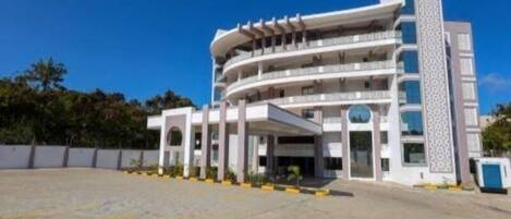 A multi-story hotel with a central courtyard, balconies, and a patterned facade.