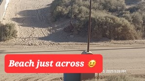 A beach with a sign indicating proximity to a beach.