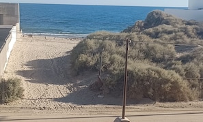 Ein Strand mit einem Schild, das die Nähe zum Strand anzeigt.