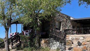 Un edificio de piedra con una escalera de madera que sube a un porche.