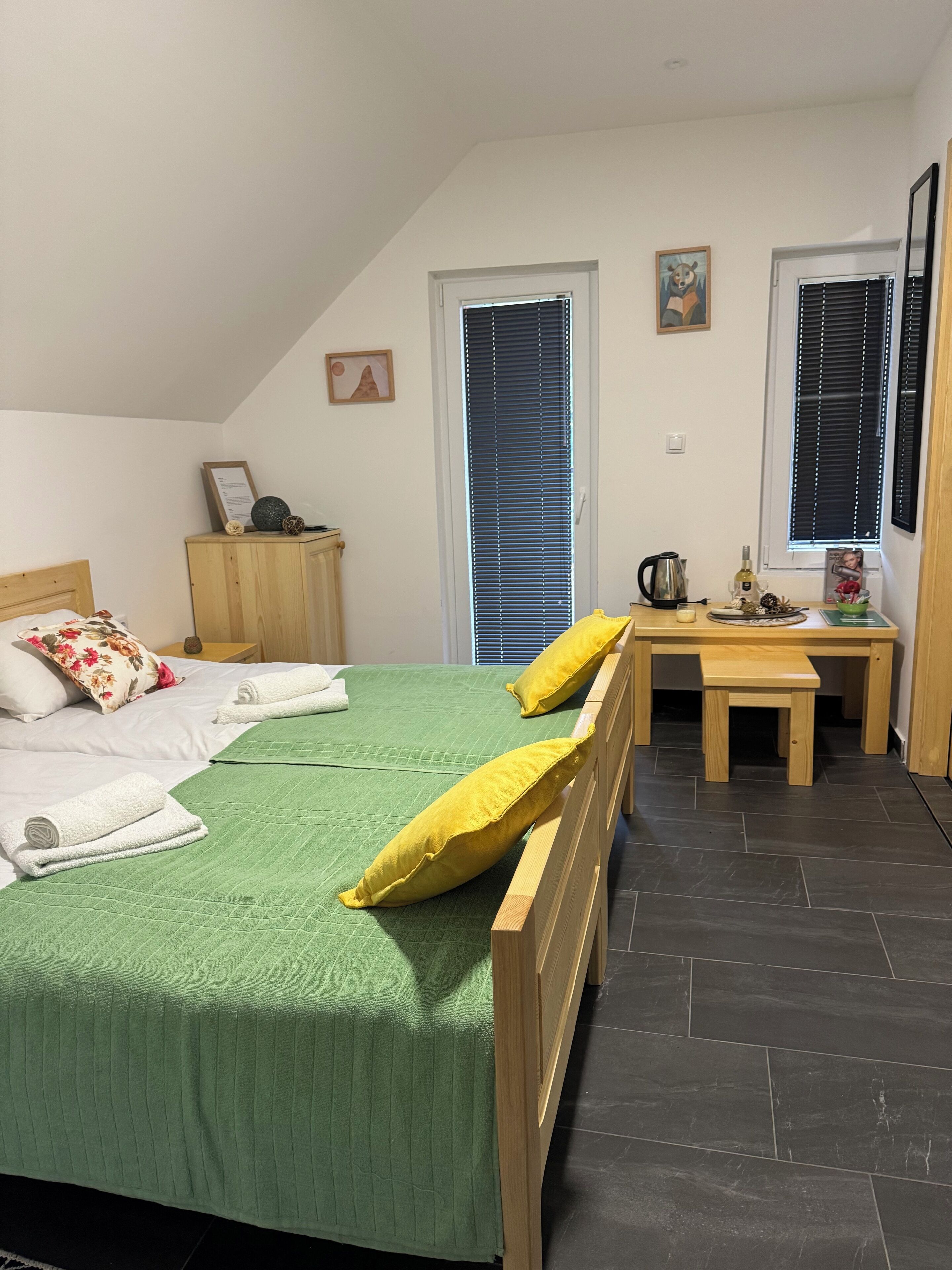 Una camera da letto con un letto, una scrivania in legno e una finestra con persiane.