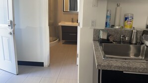 Eine moderne Küche mit Granit Arbeitsplatte, Edelstahlspüle und eingebautem Ofen.