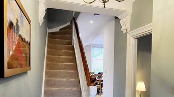 A staircase with a patterned carpet leading to a dining area.