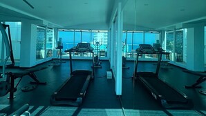 A modern gym with treadmills, weight machines, and exercise mats. - Style and comfort by the Caribbean (Gaira)