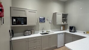 A modern kitchen with grey cabinets, a built-in oven, and a sink.