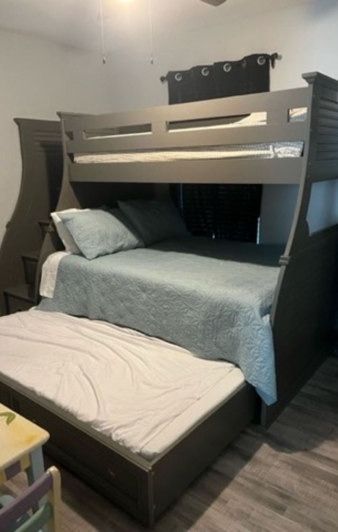 Ein Etagenbett mit unterem Bett und einer separaten Matratze auf dem Boden.