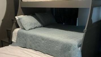 Ein Etagenbett mit unterem Bett und einer separaten Matratze auf dem Boden.