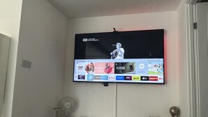 En tv-apparat som är monterad på en vägg och visar en mängd olika kanaler och program.