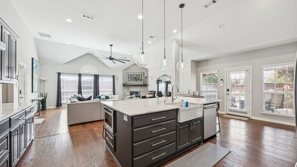A spacious kitchen with a large island, dark cabinetry, and pendant lighting. - Luxury 4BR Smart Home w/ Pool, Spa, Media Room & Pet-Friendly Yard (Frisco)