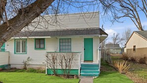 A single-story house with a green door and windows, a small front porch, and a well-maintained lawn. - 10mins to Air force base|Smart TV|Self Check-In (Mountain Home)