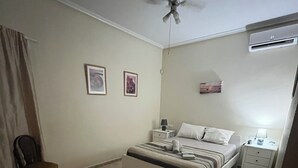 A bedroom with a bed, a chair, a ceiling fan, and a wall-mounted air conditioner. - Mediterranean villa with private pool 20 minutes from the beaches of La Marina (Catral)