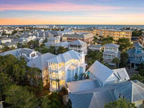 A coastal residential area with a variety of houses and a large hotel with multiple stories and balconies.