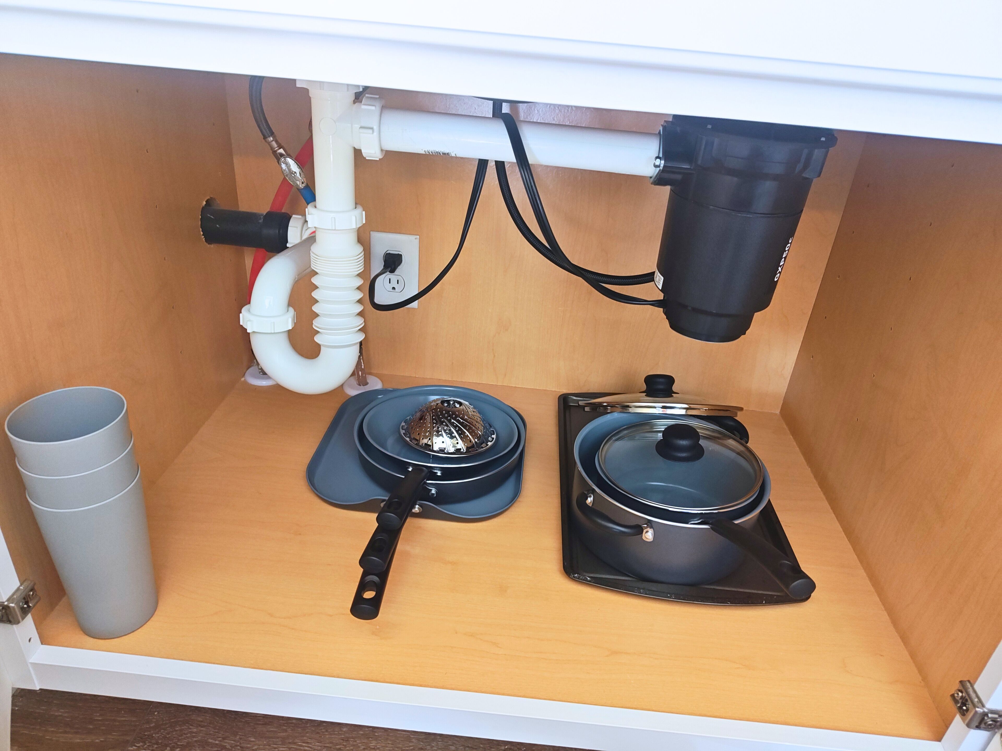 A kitchen with a sink, a kettle, and a pot.