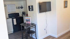 Una cocina moderna con estufa negra, cafetera y un cartel de bienvenida.