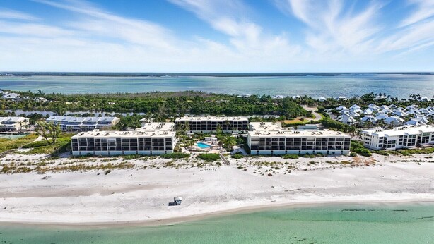 An aerial view of a coastal hotel with multiple buildings, a sandy beach, and a clear view of the ocean. - Luxurious 2BR/2BA Gulf-front Boca Grande condo (Boca Grande)