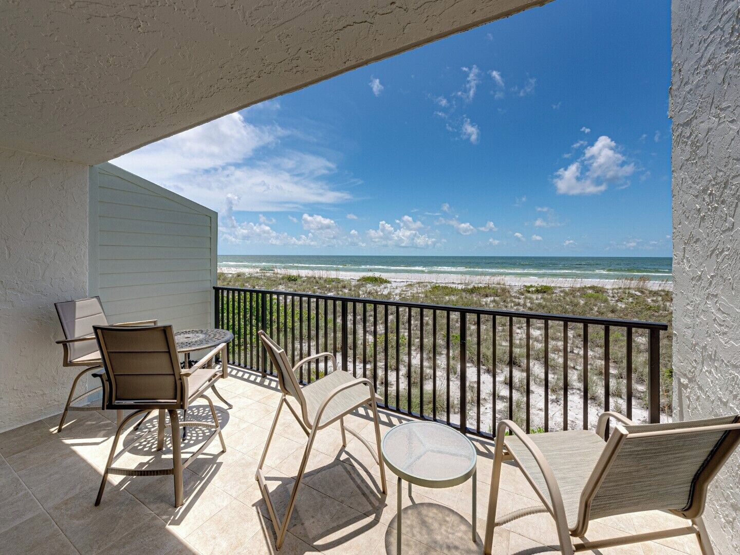 Ein Balkon mit Blick auf Strand und Meer.