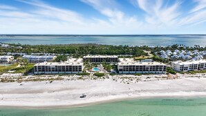 Vista aérea de un hotel costero con varias construcciones, una playa arenosa y una vista despejada del océano.
