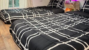 Een slaapkamer met twee bedden, houten plafond en dakraam.