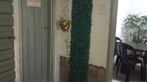 Una puerta con un letrero que dice "BANHEIRO Compartilhado" y un tapete rojo en el suelo.