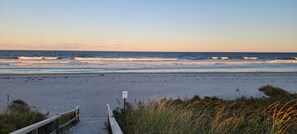A beach with a wooden walkway leading to the water, a sign indicating a no swimming area, and some vegetation in the foreground. - Pet-friendly 2-Bedroom House in Ogunquit Steps from Foot Bridge Beach (Ogunquit)