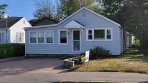 A single-story house with a front porch, a small garden, and a mailbox.