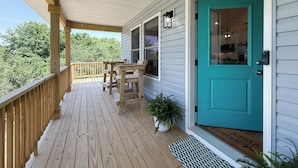 A wooden deck with a turquoise door, a small table, and chairs. - Carova Beach, 4x4, Wild Horses, New home built in 2025.
🏝 (Corolla)