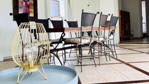Un espace repas comprenant une table ronde, des chaises et des luminaires suspendus.