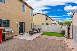A residential backyard with a barbecue grill, patio furniture, and a small lawn. - Quiet, Cozy, Clean and Safe NW Tucson Home near Omni Resort. (Tucson)