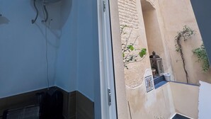 A bathroom with a shower, a towel rack, a toilet, and a sink.