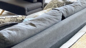 A modern hotel room with a grey sofa, a small coffee table, a TV, and a balcony with a view. - Ocean View Waikiki Luxury Ilikai Hotel~ (Honolulu)