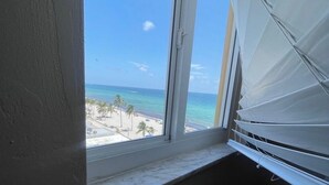 Ein Zimmer mit Fensterblick auf einen Strand.