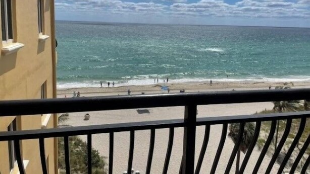 Ein Balkon mit Blick auf den Ozean und den Strand.