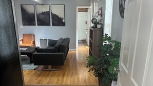A modern living room with a dark sofa, a wooden coffee table, and a potted plant.
