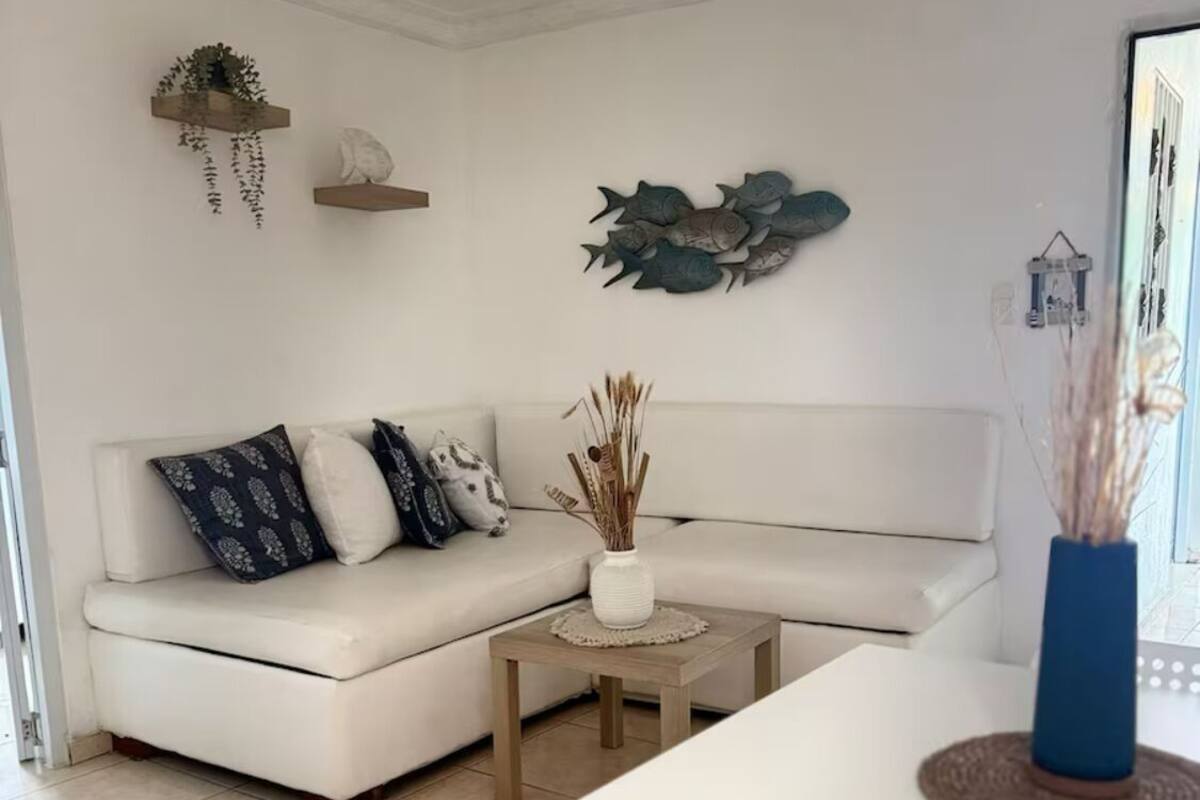 Een moderne woonkamer met een witte bank, een klein rond tafeltje en een salontafel.