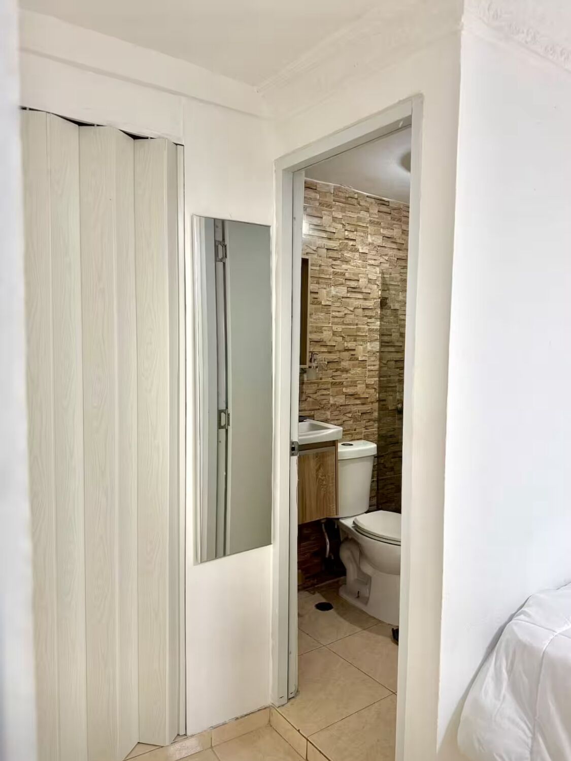 Un baño con inodoro, lavamanos y zona de ducha.