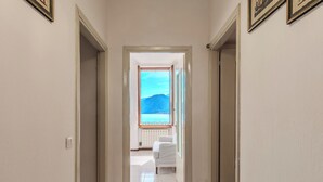 A hallway leading to a room with a view of a mountain and sea. - Martino by Interhome (Argegno)